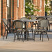 A Lancaster Table & Seating Toscano table and chairs on an outdoor patio.