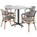 A Lancaster Table & Seating Versilla table with 4 black and white French bistro chairs.