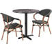 A Lancaster Table & Seating Paladina table with 2 black French bistro chairs.