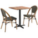 A Lancaster Table & Seating Yukon Oak table with 2 brown French bistro chairs.