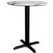 A Lancaster Table & Seating round table with a white marble top and black base.