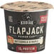 A black and white Kodiak Cakes Buttermilk and Maple Flapjack Cup container with a lid.