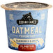 A blue and white Kodiak Cakes oatmeal cup with blueberries and cream.