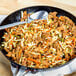 A skillet of Barvecue plant-based shredded chicken and vegetables.