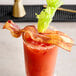 A bloody mary with Riff's Smokehouse Red Curry Bacon on a stick.