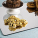 A Cal-Mil rectangular mirror tray with a cake and cookies on it in a bakery display.