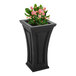 A Mayne black rectangular planter with a plant inside on an outdoor patio table.