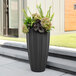 A graphite gray Mayne Sedona rectangular planter with flowers in it.