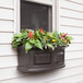 A Mayne Nantucket Espresso window box with flowers and plants in it.