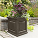 An espresso Mayne Nantucket planter with flowers on an outdoor table.