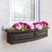 A black rectangular Mayne Nantucket window box with pink and white flowers.