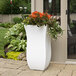 A white rectangular Mayne Valencia planter with flowers in it.
