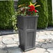 A Mayne Cape Cod graphite gray rectangular planter with flowers in it.