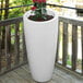 A white Mayne Modesto planter with a plant in it.