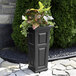 A black rectangular Mayne Nantucket planter with a plant in it.