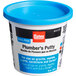 A white Oatey tub of plumber's putty with a blue lid.