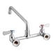 A chrome Regency wall mount faucet with silver and red and blue knobs.