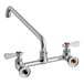 A chrome Regency wall mount faucet with two handles and a 12" swing spout.