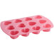 A Wilton pink silicone mold with 12 heart-shaped compartments.