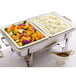 A tray of food with a white Hall China food pan of vegetables and a white gravy boat on a table.