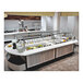 A Vollrath 6-Series custom food buffet on a counter with food in containers.