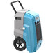 An AlorAir Storm Pro 85 blue and grey commercial dehumidifier with black wheels.
