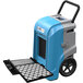 An AlorAir Storm Ultra LGR 90 blue and grey commercial dehumidifier with a black handle on wheels.