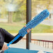 A woman using a Lavex chenille duster sleeve to dust.