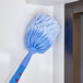 A Lavex blue and white corner duster brush on a wall.