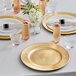 A table set with gold beaded rim charger plates and glasses.