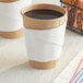 A Choice linen-feel coffee cup sleeve wrapped around a coffee cup.