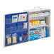A white and blue First Aid Only 3-shelf cabinet with a blue and white cover.