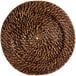 An Acopa round wicker charger plate with a spiral pattern.