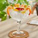 An Acopa margarita glass filled with shrimp and garnished with lemon slices.
