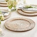 A table set with Acopa Blond Rattan Charger Plates and white flowers.