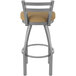 A stainless steel Holland Bar Stool outdoor counter stool with a tan cushion.