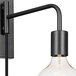 A Globe matte black plug-in wall sconce with a clear light bulb hanging from it.