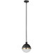 A black and brass Globe pendant light with white glass inside hanging in a restaurant.