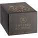 A black Twisted Alchemy box with gold text and a logo on the counter.
