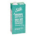 A blue and white carton of Silk Organic Unsweetened Soy Milk with a white cap.
