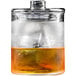 A Flavour Blaster rocks glass with a lid filled with brown liquid and ice on a counter.
