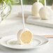 A white plate with Chalet Desserts Italian cream cake pops on sticks.