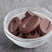 A bowl of Valrhona Guanaja 70% dark chocolate feves.