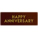 A rectangular Chocolatree chocolate decoration with gold "Happy Anniversary" text on a red background.