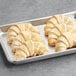 A baking tray with six Gourmand Pastries French Butter Croissants.