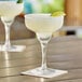 Two Acopa Classic Margarita glasses filled with margaritas on a table.
