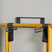 A Lancaster Table & Seating wooden tray stand rack with black straps.
