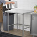 A Regency stainless steel open base work table in a kitchen.