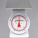 A white scale with a red dial and white base.