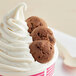 A cup of soft serve ice cream with Homefree double chocolate chip cookies on top.